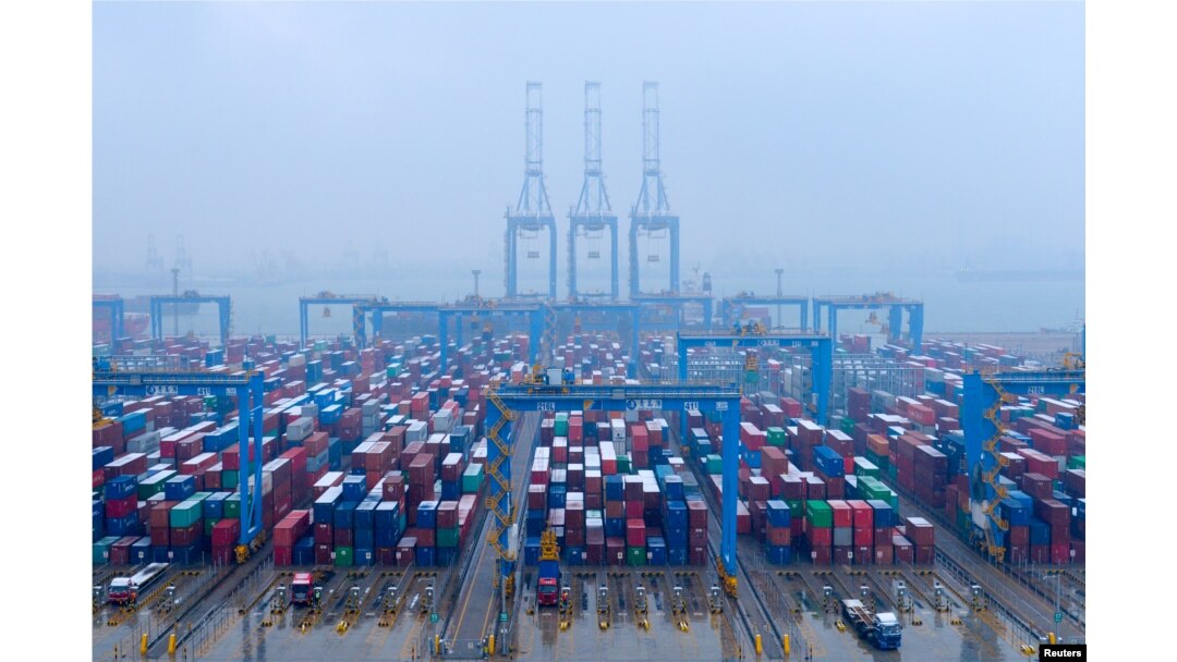 FILE - Containers and trucks are seen at an automated container terminal in Qingdao port, Shandong province, China, Dec. 10, 2018.