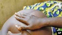 A maternal and child health aid examines an expectant mother at a local clinic in Sierra Leone