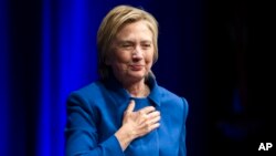 Hillary Clinton places her hand over her heart as she walks to the podium to address the Children's Defense Fund's Beat the Odds celebration at the Newseum in Washington, Nov. 16, 2016.