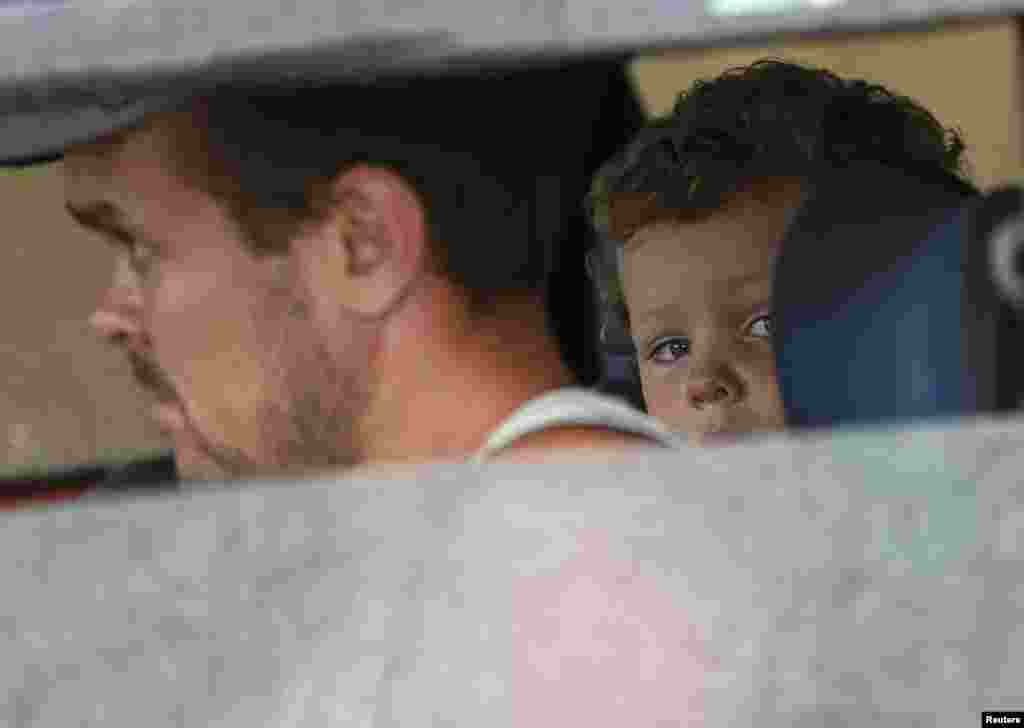 A child looks on from a car as he returns with his parents to Luhansk, at a checkpoint in Debaltseve, Ukriane, Sept. 9, 2014.