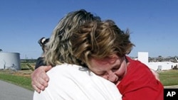 An emotional Donna Fredericks, right, cries as she hugs co-worker Martha Mitchell. A tornado destroyed much of the small community of Hackleburg, Alabama.