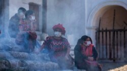 Mujeres indígenas en Guatemala usan máscaras para protegerse en una plaza pública.