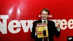 Editorial Director of Russian Newsweek Leonid Bershidsky gives a thumbs up while holding the first issue in Moscow 07 June 2004