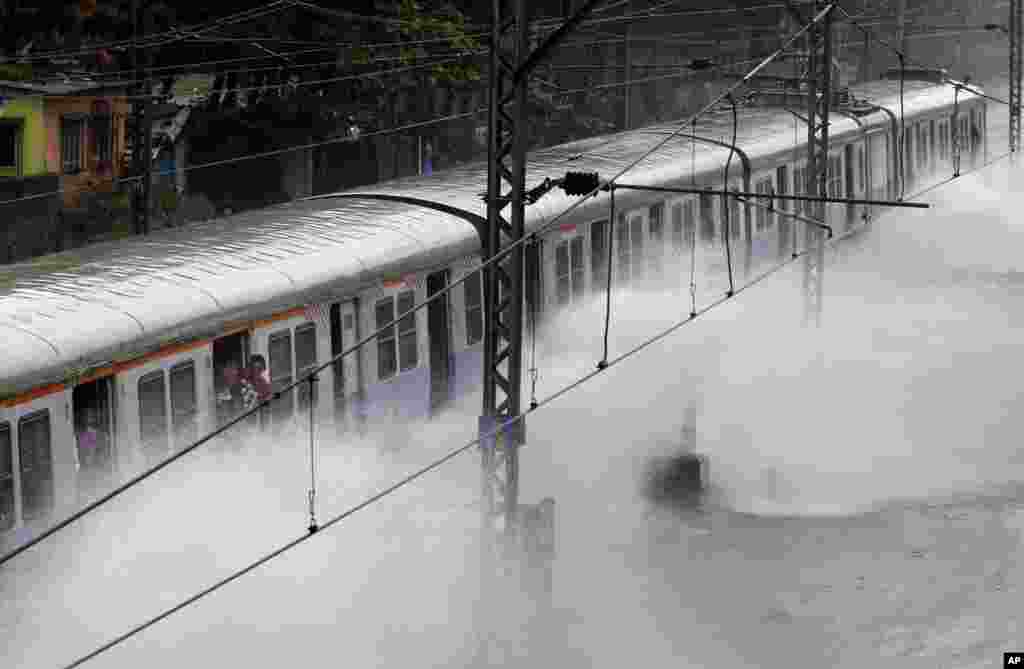 A local train moves through a flooded railway track after heavy rains in Mumbai, India.