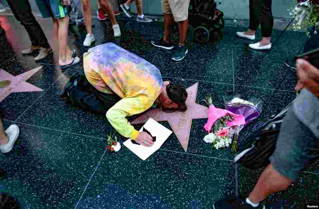 J.R. Kail kisses the star for late country music entertainer Glen Campbell on the Hollywood Walk of Fame in Los Angeles, California, Aug. 8, 2017.