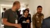 El jefe de la Policía de Inmigración, mayor general Surachate Hakparn, camina con la joven saudí Rahaf Mohammed Alqunun antes de salir del aeropuerto de Suvarnabhumi en Bangkok, Tailandia, el 7 de enero de 2019.
