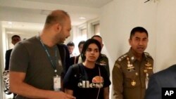 In this photo released by the Immigration Police, Chief of Immigration Police Maj. Gen. Surachate Hakparn, right, walks with Saudi woman Rahaf Mohammed Alqunun before leaving the Suvarnabhumi Airport in Bangkok, Thailand, Jan. 7, 2019.