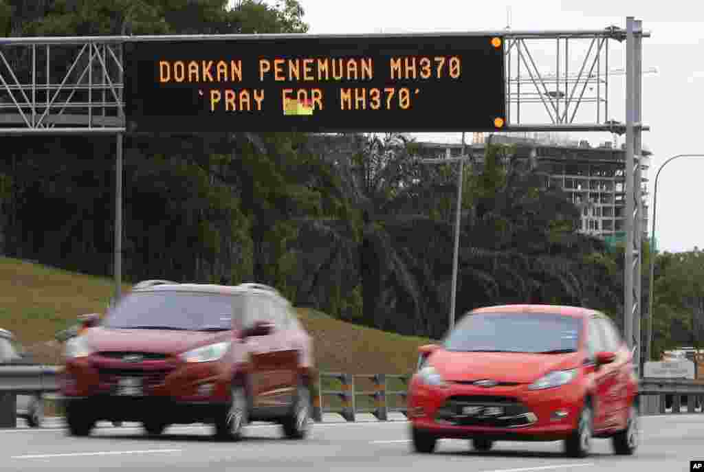 Motorists drive past an electronic board displaying &quot;Pray for MH370&quot; in Shah Alam, near Kuala Lumpur, Malaysia, March 16, 2014.