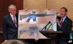 Sen. Edward Markey, D-Mass., left, and Sen. Richard Blumenthal, D-Ct., display a photo of a plastic gun on Capitol Hill in Washington, July 31, 2018. Democrats are calling on President Donald Trump to reverse an administration decision to allow a Texas company to make blueprints for a 3D-printed gun available online.