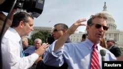 Republican U.S. Senators Ted Cruz (L) and Rand Paul (R) talk to reporters as they arrive to speak at an anti-'Obamacare' rally on the west lawn of the U.S. Capitol in Washington, September 10, 2013.