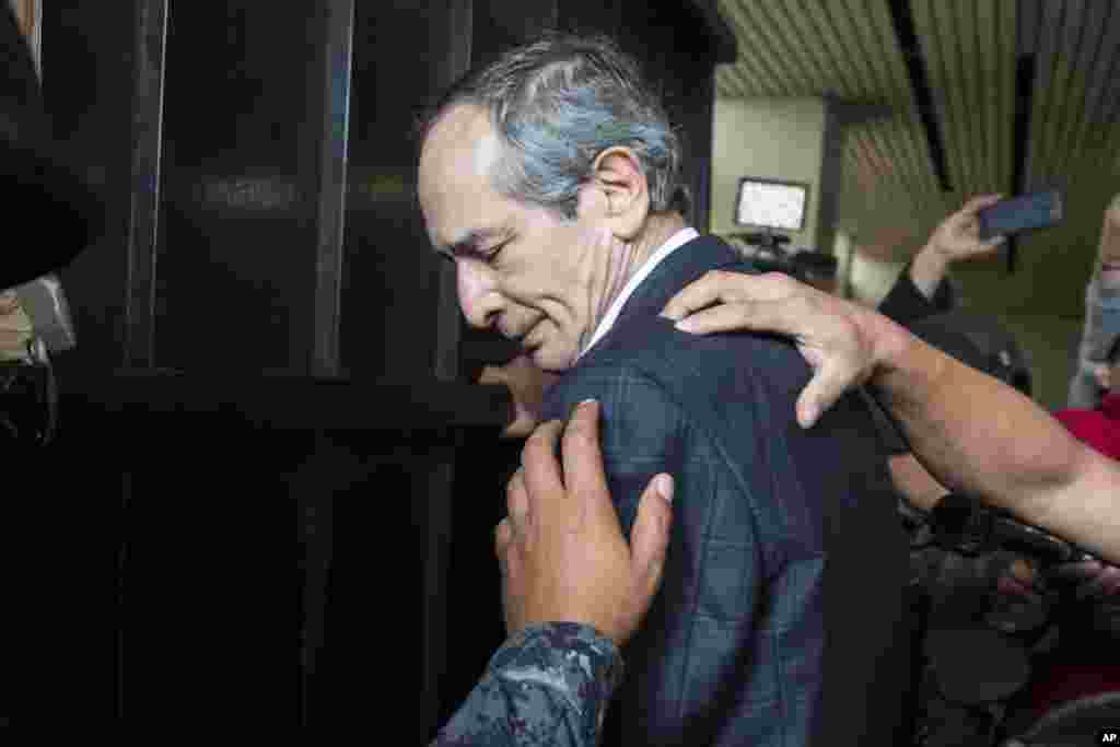 Police officers pat down former Guatemalan President Alvaro Colom before escorting him into a courthouse in Guatemala City. Colom, who governed from 2008 to 2012, has been detained in a corruption case according to special prosecutor Juan Francisco Sandoval.