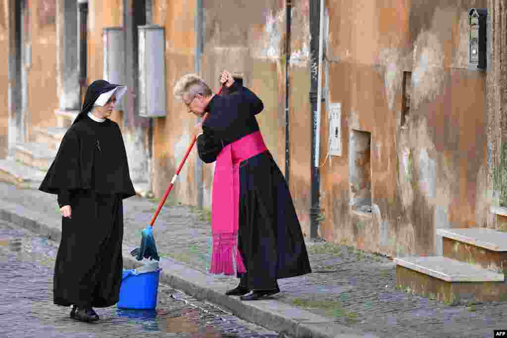 Bishop Josef Bart cleans the street in front of the Santo Spirito in Sassia church before the arrival of Pope Francis for the Holy Mass on Divine Mercy in Rome, Italy.