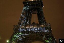 FILE- Artwork entitled "One Heart One Tree" by artist Naziha Mestaoui is displayed on the Eiffel tower ahead of the 2015 Paris Climate Conference, in Paris, Nov. 29, 2015.