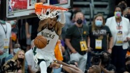 Milwaukee Bucks forward Giannis Antetokounmpo, top, dunks over Phoenix Suns guard Chris Paul during the second half of Game 5 of basketball's NBA Finals, Saturday, July 17, 2021, in Phoenix. (AP Photo/Ross D. Franklin)
