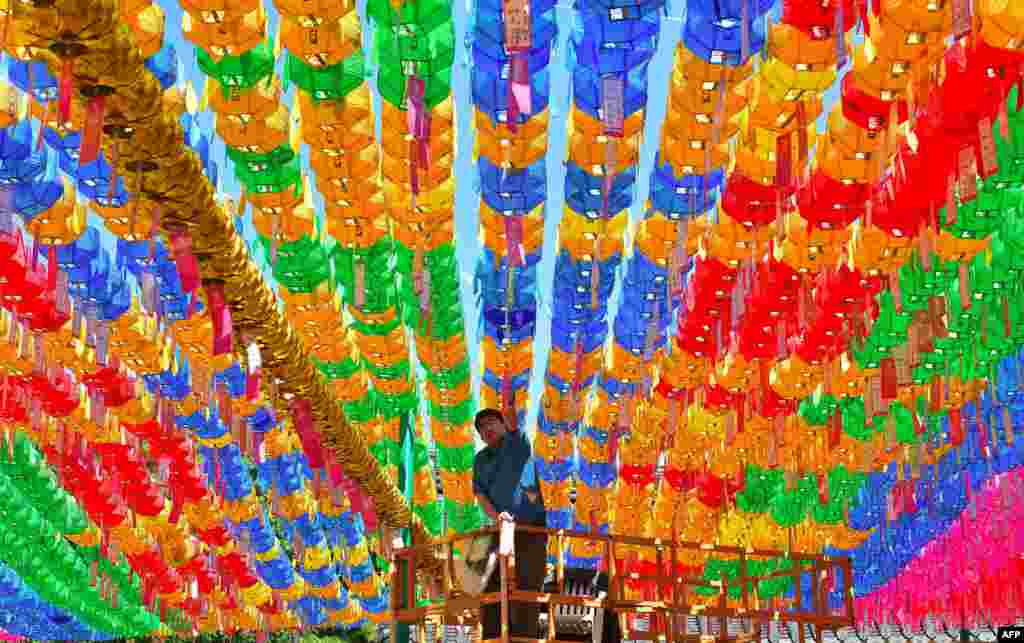 Seorang pekerja dari Korea Selatan menempelkan kartu-kartu nama dengan harapan sebagai pengikut Buddha ke arah lentera teratai menjelang ulang tahun Buddha di kuil Jogye di Seoul.