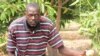 South Sudanese environmentalist turned farmer Paul Alim Amuol holds a mango on one of the 800 trees on his farm in Bor, Jonglei state. 