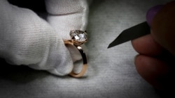 A worker inspects a ring set with an Aether diamond made from captured CO2, at the RFG Manufacturing Riviera jewelry design facility in New York City, New York, September 30, 2021. (REUTERS Mike Segar)