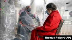 The tent includes a construction-grade plastic barrier with built-in plastic sleeves to prevent the spread of the coronavirus, in Louisville, Colorado, on Wednesday, Feb. 3, 2021. (AP Photo/Thomas Peipert)