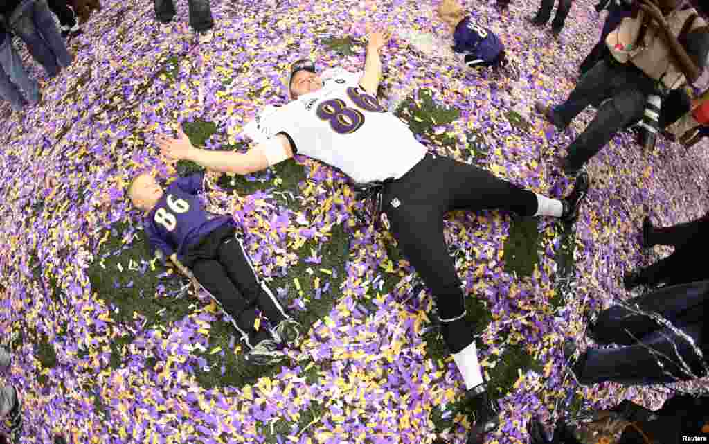 Baltimore Ravens tight end Billy Bajema (86) lies in the confetti on the field with his children as he celebrates his team defeating the San Francisco 49ers in the NFL Super Bowl XLVII.