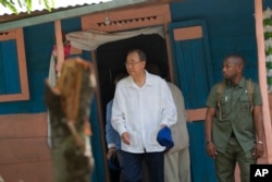 FILE - U.N. Secretary-General Ban Ki-moon walks out after visiting the house of a cholera victim during the launching of sanitation campaign in Hinche, Haiti, July 14, 2014.