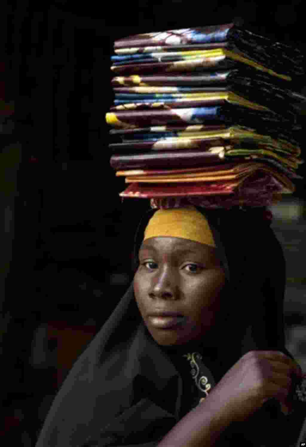 A cloth seller waits in hope of selling some pieces to a wholesale buyer, as sellers said their business was suffering following the recent coup, at the Grand Market in Bamako, Mali Saturday, March 31, 2012. The countries neighboring Mali have condemned t