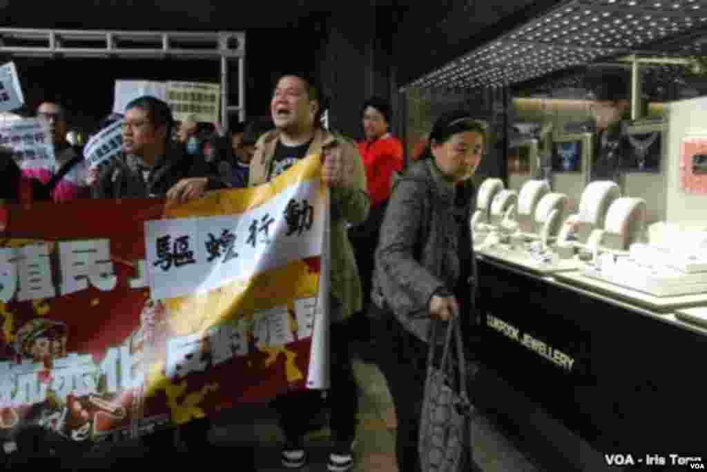 A female tourist from mainland China (right) tries to avoid the protesters. (Iris Tong, VOA)