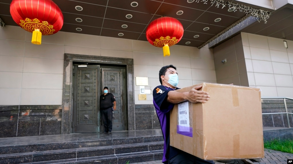 资料照片：一名联邦快递雇员从被美国下令关闭的中国驻休斯顿领事馆搬走一个纸箱。(2020年7月23日)(photo:VOA)