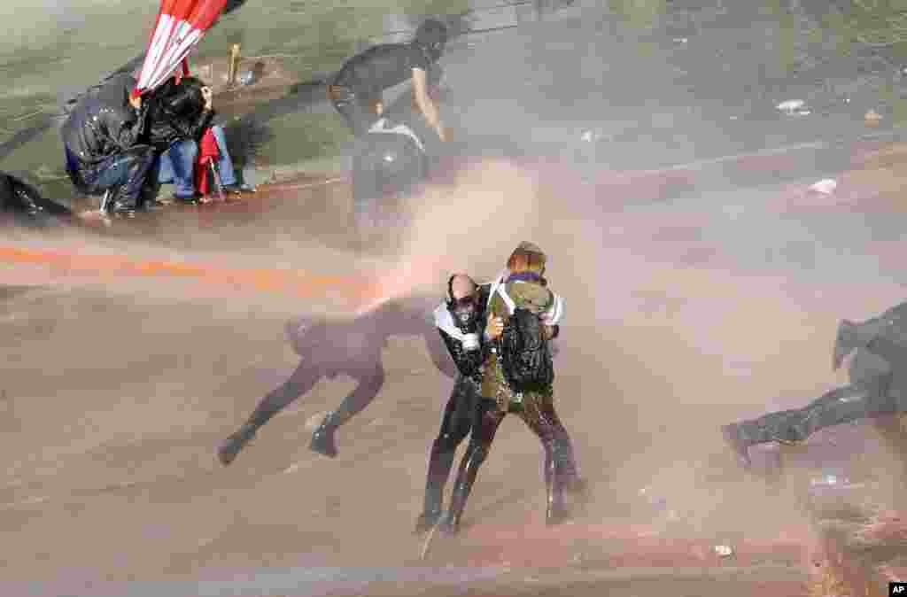 Riot police use tear gas and water canon to disperse protesters as they try to march to the parliament during a protest against Turkey&#39;s ruling AK Party and Prime Minister Tayyip Erdogan in Ankara.