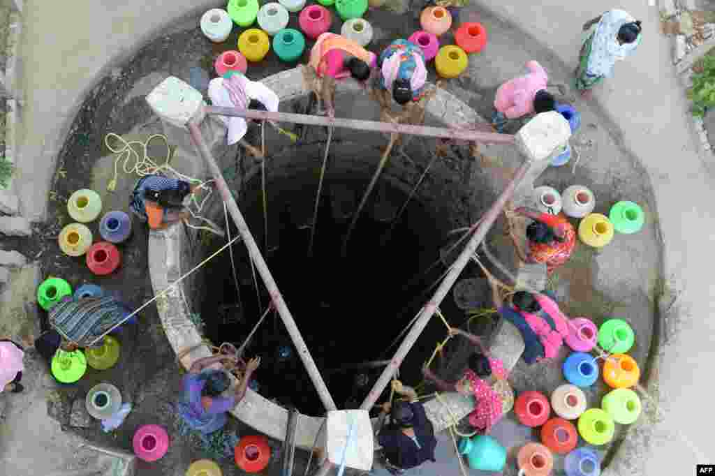 Indian residents fetch drinking water from a well on the outskirts of Chennai. 