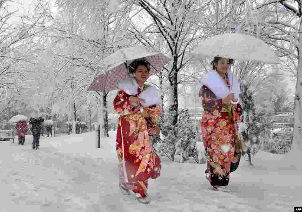 Young women dressed in kimonos walk on a snow-covered street to attend a coming-of-age ceremony in Tokyo. A storm system grasped central Japan Monday, causing heavy snowfall around the capital city. 