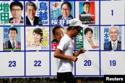 A jogger runs past candidate posters for the Tokyo Governor election in Tokyo, Japan, July 31, 2016.
