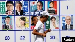 Seorang pria melewati poster kandidat Gubernur Tokyo, Jepang, 31 Juli 2016. 