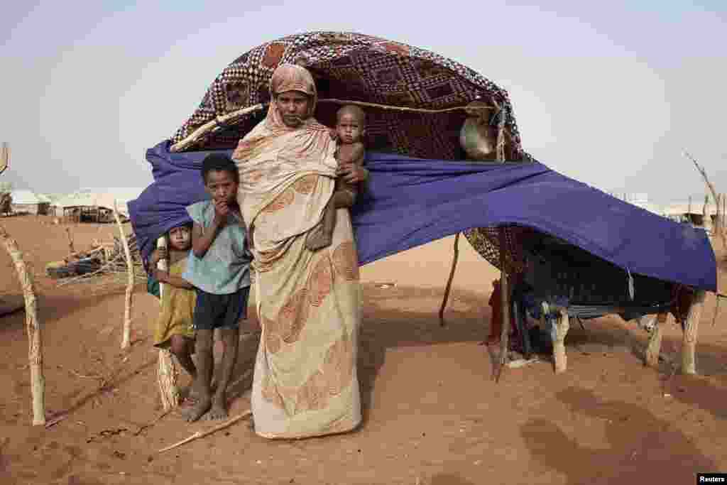 Zeinab Mint Hama, 25, with her children Zuber (L), Bon Oumar (2nd L) and Seydna Ali in front of her shelter at Mbera refugee camp in southern Mauritania.
