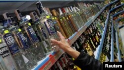 Serorang pembeli mengambil sebotol vodka dari jajaran minuman keras di sebuah supermarket di Benidorm, Rusia (Foto: dok).