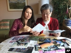 Florence Seto (right) and her granddaughter, Michelle Kalehua Kukahiko, look over family photos in Medford, Oregon.