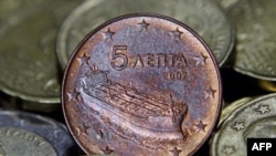 A Greek five-cent euro coin depicting a tanker is seen amongst other coins in Athens, Greece, February 15, 2012.