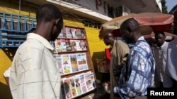 Des Guinéens lisent le journal à Conakry, Guinée, le 7 décembre 2009.