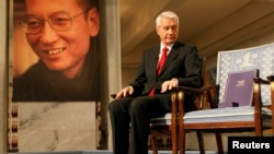 FILE - Chairman of the Norwegian Nobel Committee Thorbjoern Jagland looks down at the Nobel certificate and medal on the empty chair where this year's Nobel Peace Prize winner jailed Chinese dissident Liu Xiaobo would have sat, as a portrait of Liu is seen in the background, during the ceremony at Oslo City Hall, Dec. 10, 2010. 