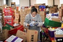 Seorang karyawan memeriksa informasi pengiriman untuk paket saat Festival Belanja Online "Double Eleven" di Provinsi Jiangsu, China timur pada tanggal 2 November 2020. (Foto: AFP)