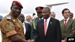 Burkina Faso's Lieutenant Colonel Isaac Zida (L) welcomes Nigerian President Goodluck Jonathan (C) next to French Ambassador Gilles Thibault (R) upon their arrival at Ouagadougou airport, Nov. 5, 2014. 