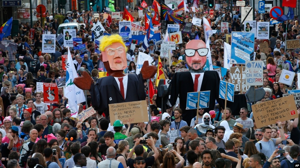 Protesters carry effigies of US President Donald Trump and Belgian PM Charles Michel during a demonstration in the center of Brussels, May 24, 2017. Demonstrators marched in Brussels ahead of a visit of US President Donald Trump and a NATO heads of state summit that will take place Thursday. 