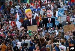 Protesters carry effigies of US President Donald Trump and Belgian PM Charles Michel during a demonstration in the center of Brussels, May 24, 2017.