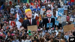 2017年5月24日，布鲁塞尔抗议者举着美国总统川普和比利时首相米歇尔的模拟像在市中心游行抗议。