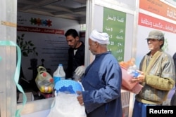 Men stand in line to sell their garbage at a center that offers residents money in exchange of their recyclable garbage in an attempt to keep the city streets clean in Cairo, March 11, 2017.