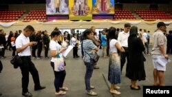 People line up for their early vote for the upcoming Thai election at a polling station in Bangkok, Thailand, March 17, 2019.