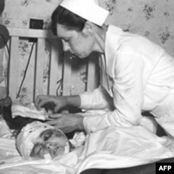 A nurse cares for a young victim of the 1937 explosion