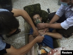 A man, affected by what activists say is nerve gas, breathes through an oxygen mask in the Damascus suburbs of Jesreen, Aug. 21, 2013.