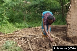 Agness Milonje, a flood victim in southern Malawi, collects pieces of her flood-damaged home.