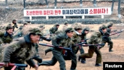 북한 조선중앙통신이 13일 공개한 노동적위대원들의 군사훈련 장면. 미국에 대한 적대 구호가 세겨져 있다.