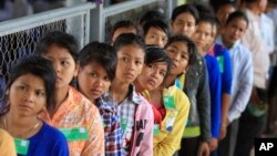 FILE - Cambodian villagers line up at an entrance before the final statements from Nuon Chea and Khieu Samphan at the U.N.-backed war crimes tribunal in Phnom Penh.